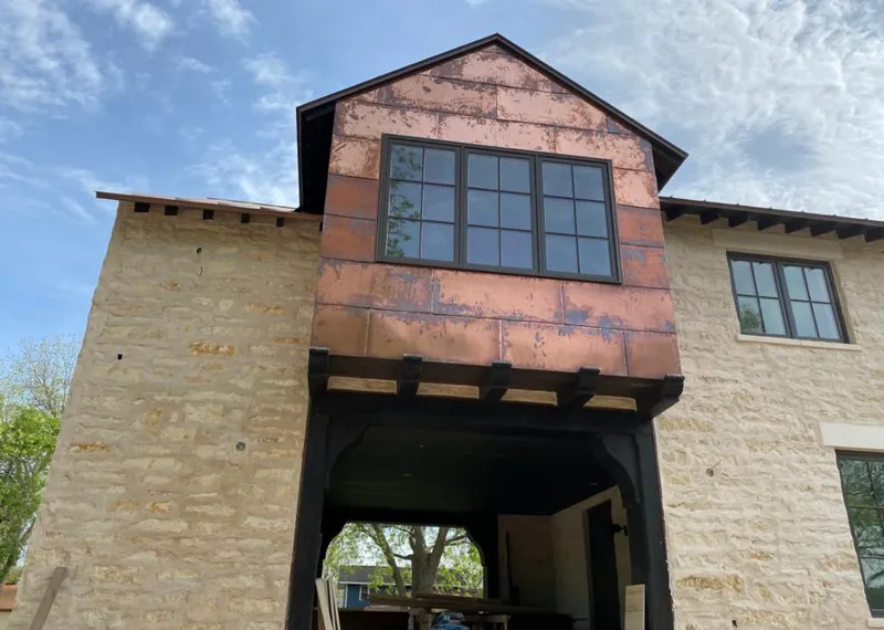 Copper metal panel facade on a stone building for Skylight Installation in Two Rivers